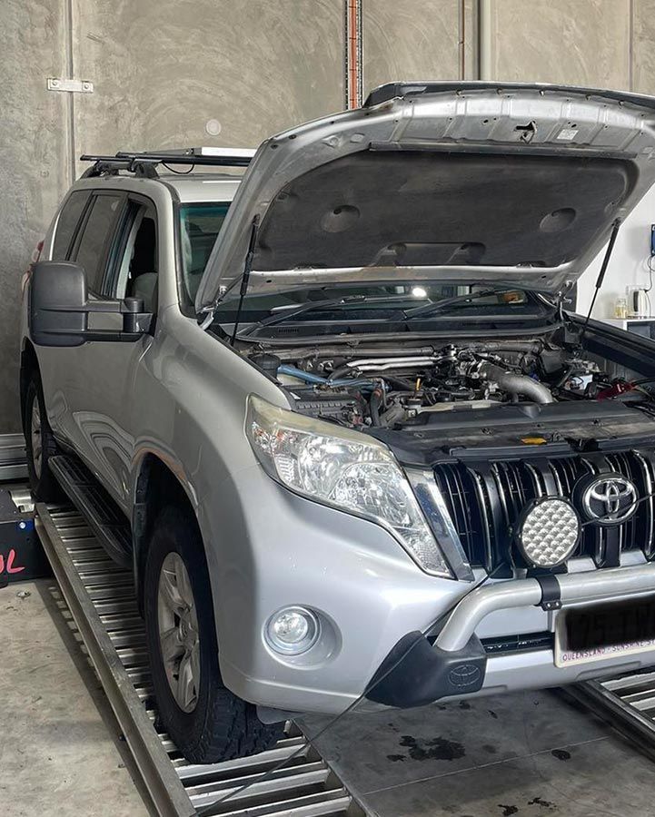 A Silver Toyota Land Cruiser With Its Hood Open In A Garage — Dieselflash Whitsundays in Bowen, QLD