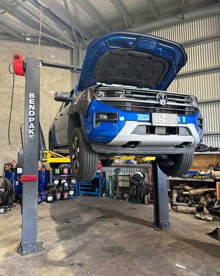 A Blue Volkswagen Amarok Is On A Lift In A Garage — Dieselflash Whitsundays in Proserpine, QLD