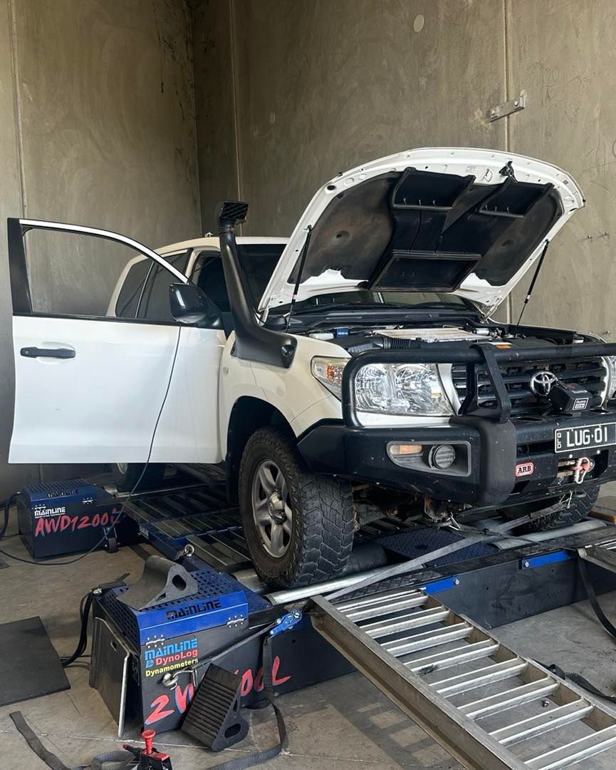A White Truck With The Hood Up Is Sitting On A Ramp In A Garage — Dieselflash Whitsundays in Airlie Beach, QLD