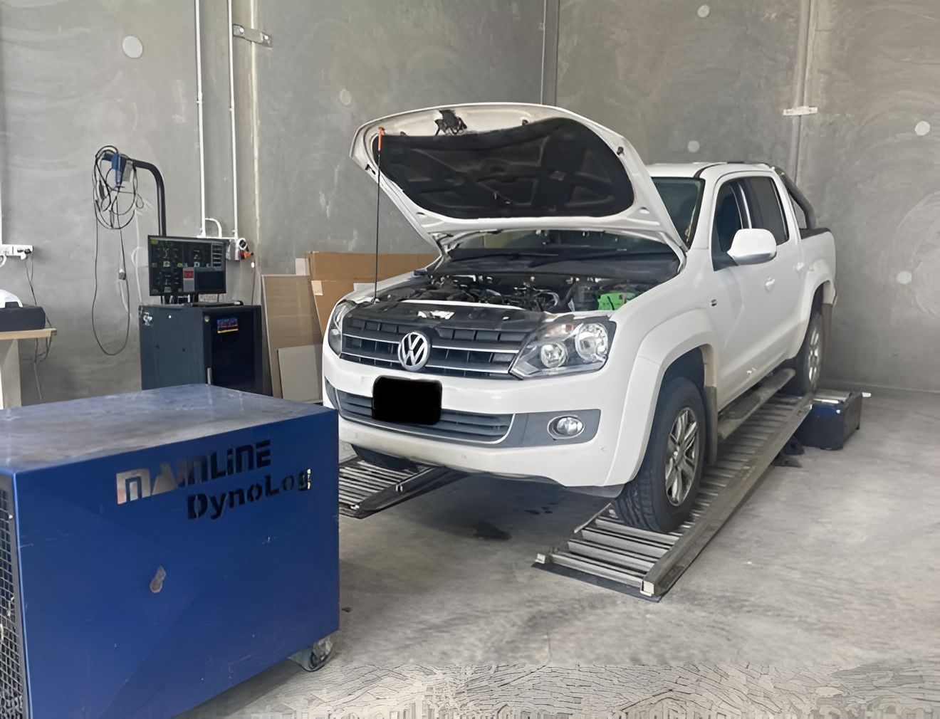 A White Truck With Its Hood Up Is Sitting On A Ramp In A Garage — Dieselflash Whitsundays in Mackay, QLD