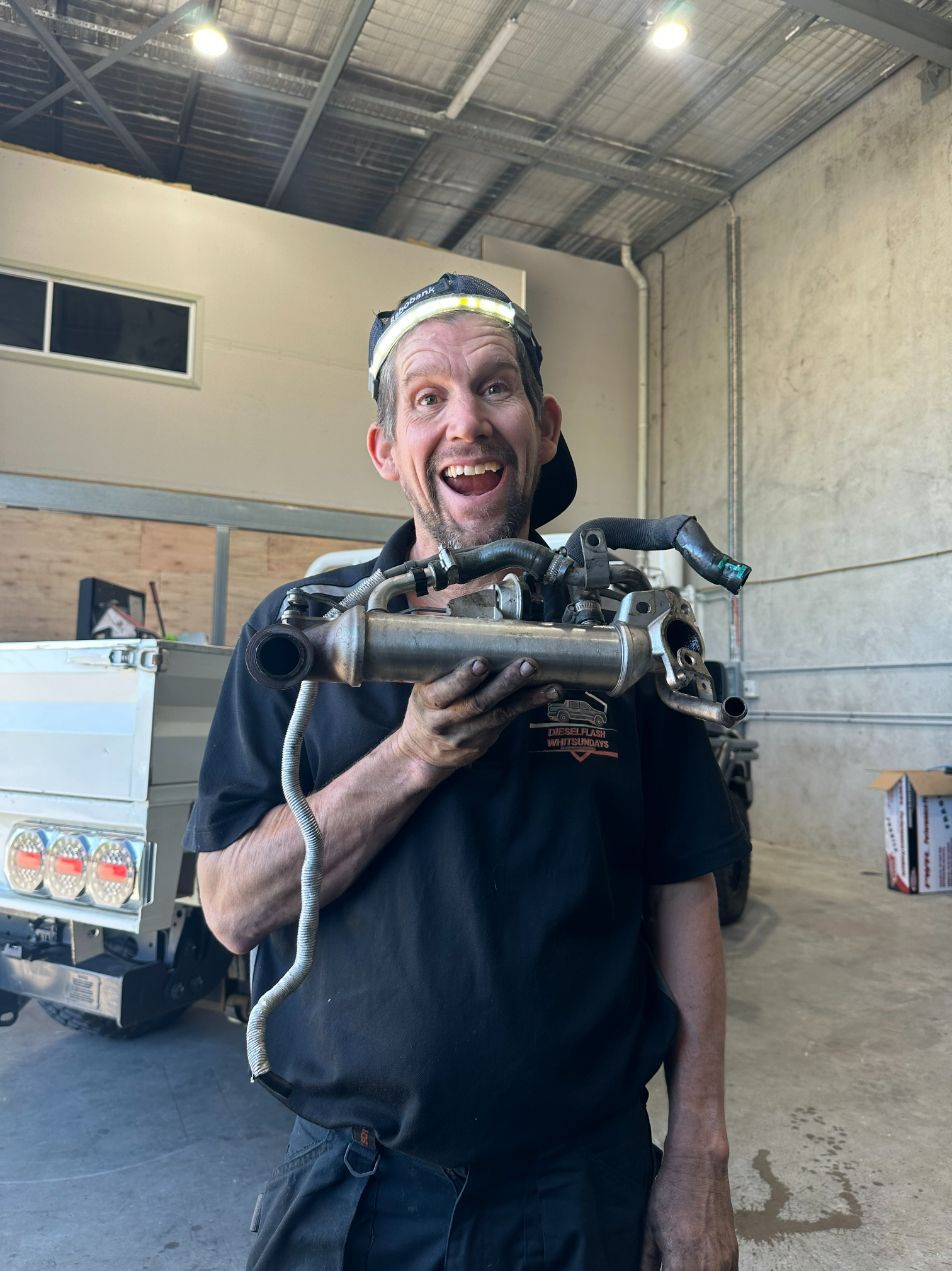 A Man is Holding a Pipe in His Hands in a Garage — Dieselflash Whitsundays in Proserpine, QLD
