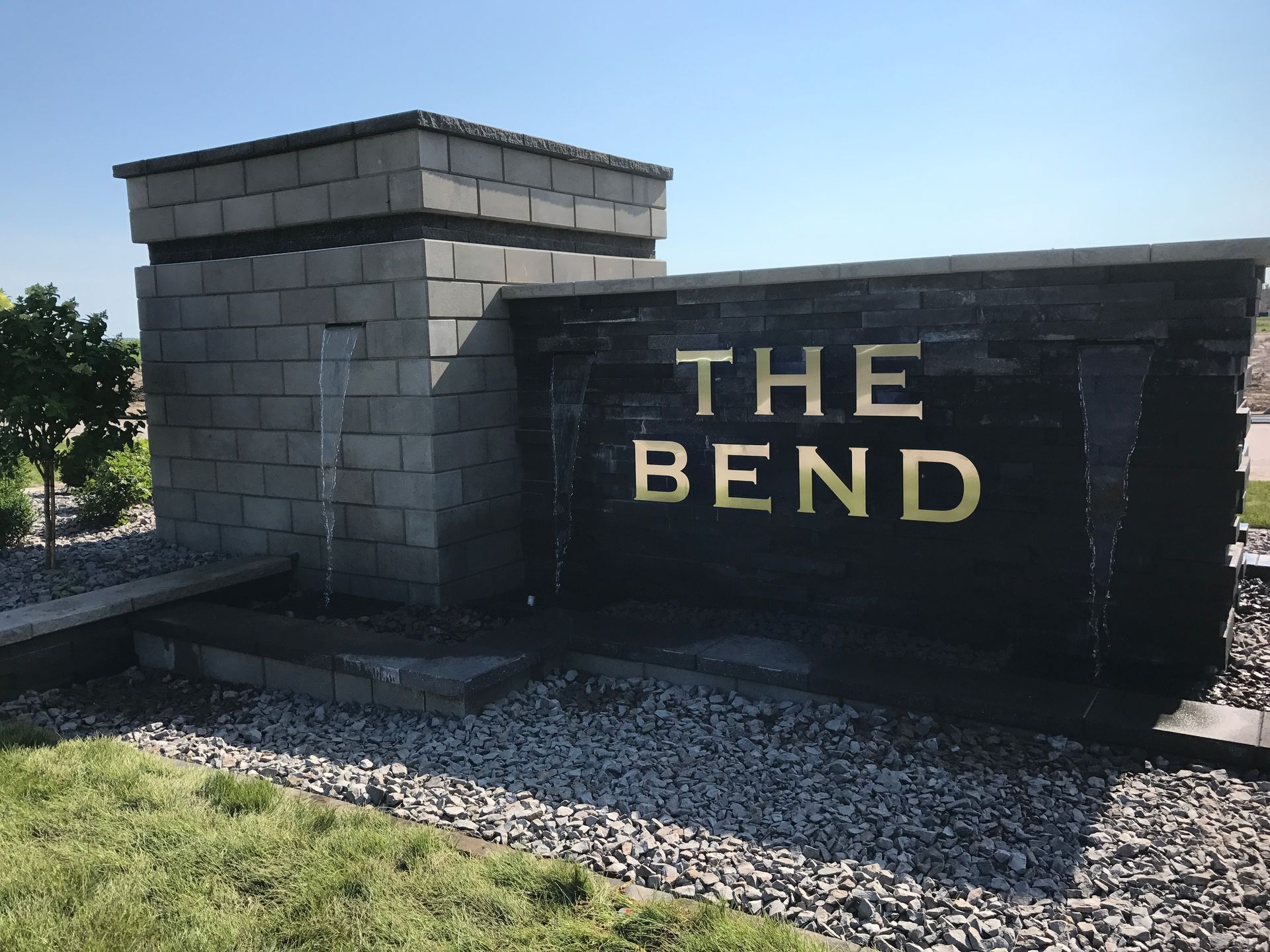 A stone water feature with a sign that reads 