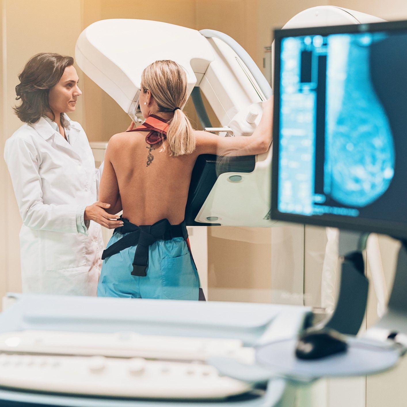 A woman is getting a mammogram from a doctor. A woman is getting a mammogram from a doctor.