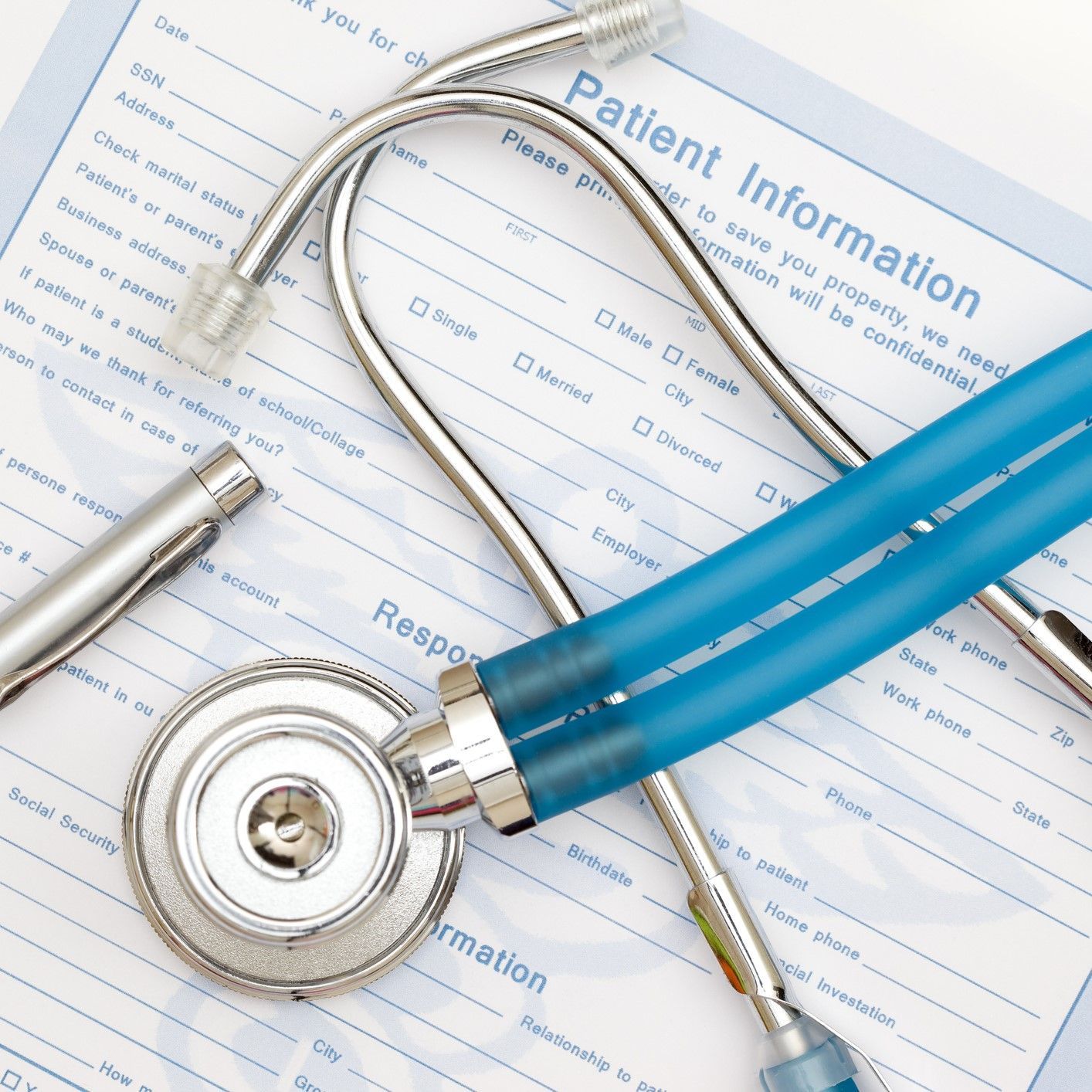 A stethoscope is laying on top of a patient information form