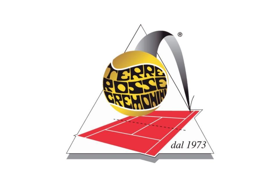 Logo di una pallina da tennis oro e nera su un campo rosso, con la scritta “dal 1973”
