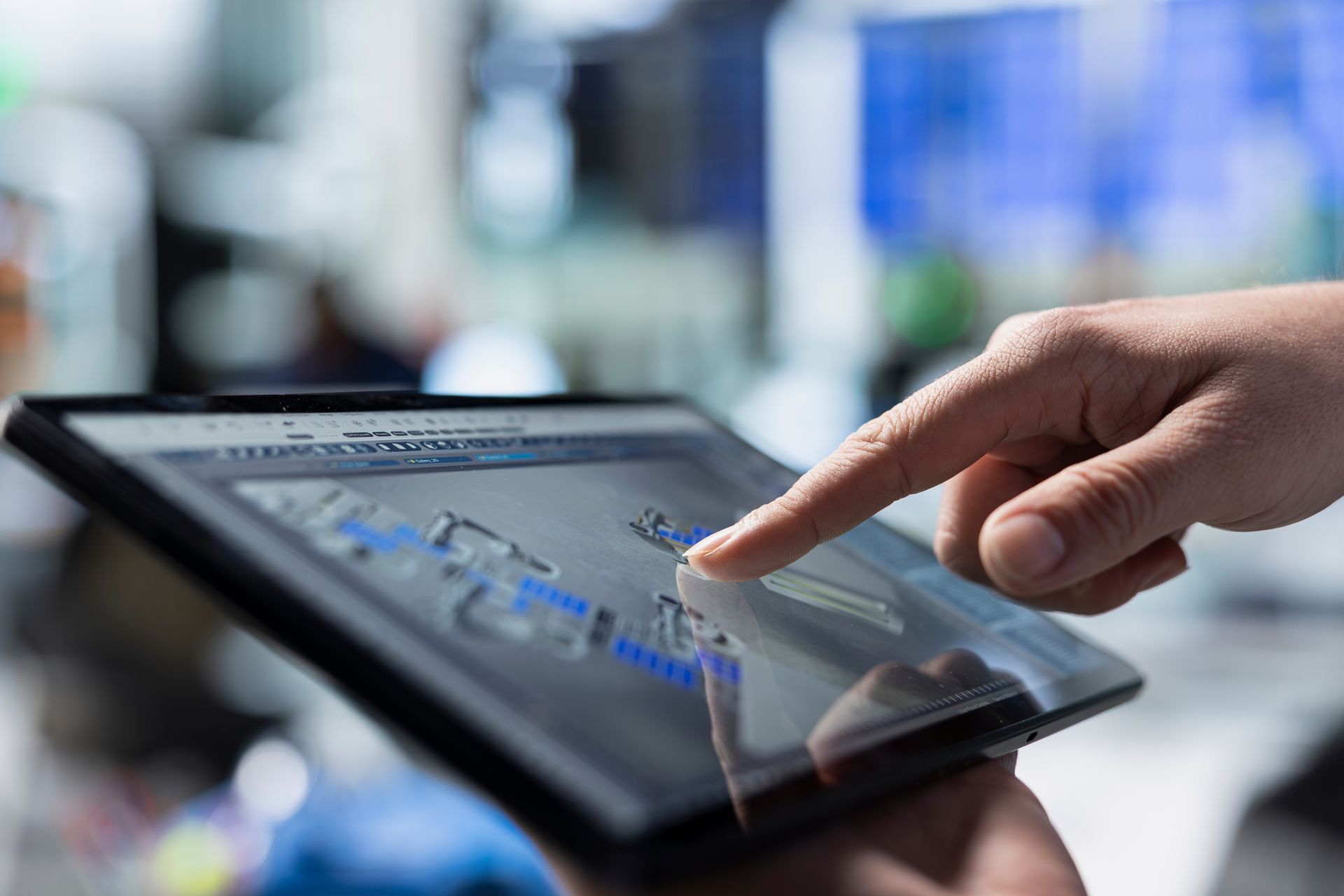 Hand tapping a tablet screen with a map app open in a blurred indoor setting