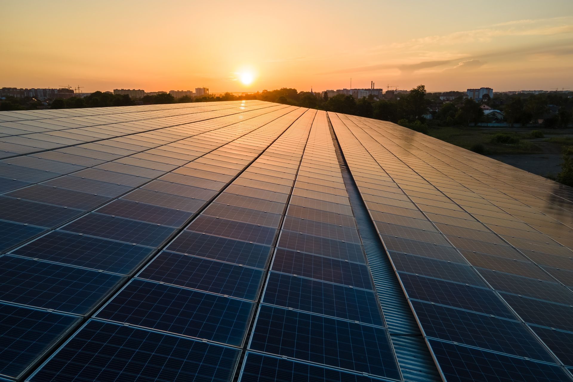 Sunset over a large solar panel array stretching into the distance