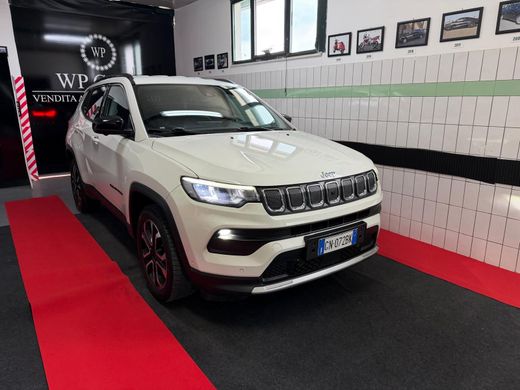 SUV Opel Mokka bianco parcheggiato in uno showroom con interni neri e rossi.
