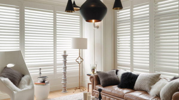 a living room with a couch , chair , lamp and white shutters All Window Decor (817) 448-3393.