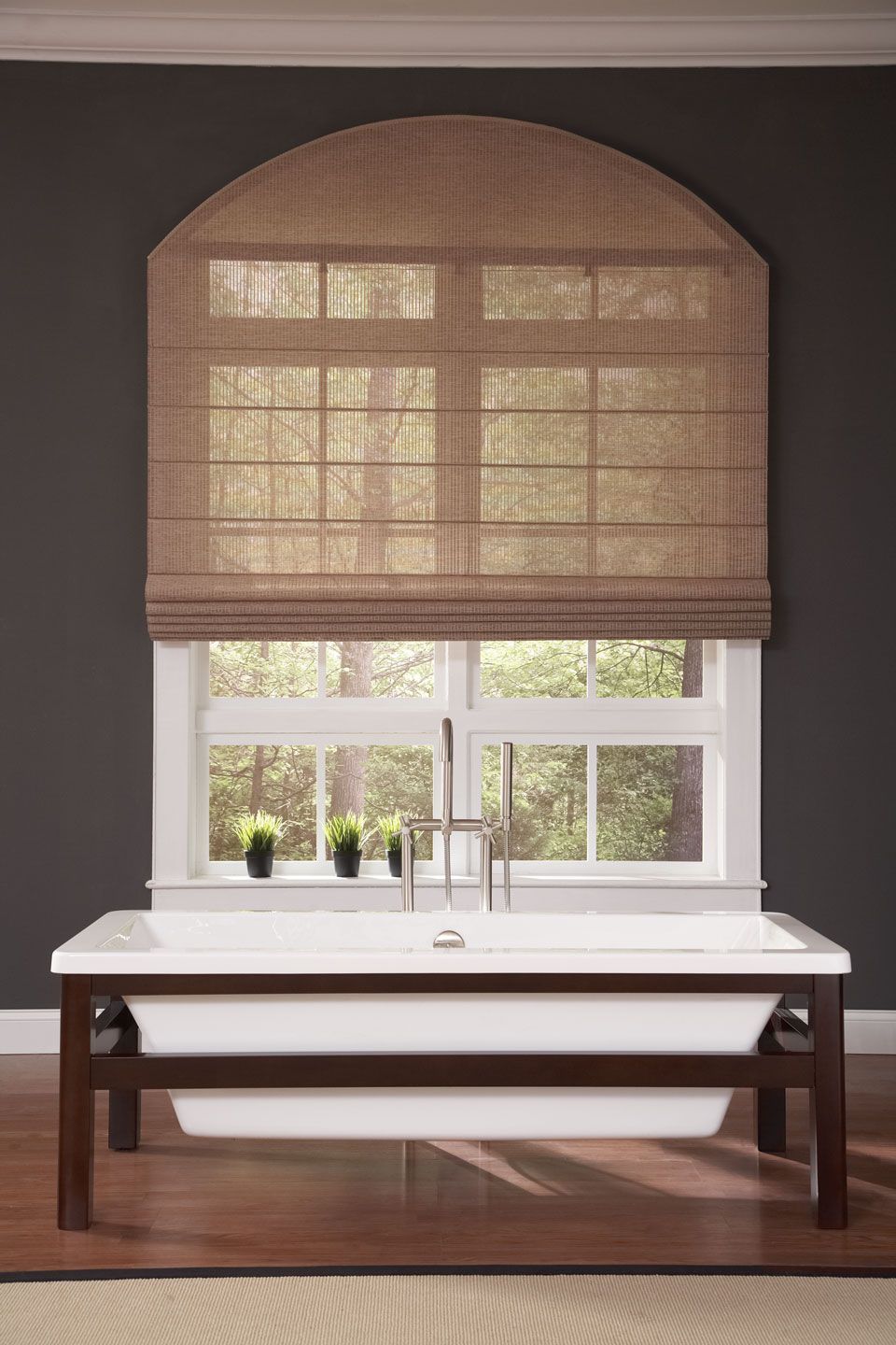 a bathroom with a bathtub and a window with a roman shade All Window Decor (817) 448-3393.