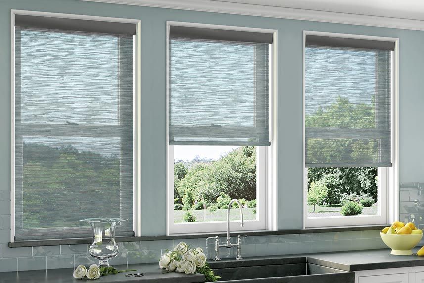 a kitchen with three windows and a sink with roller shades All Window Decor (817) 448-3393.