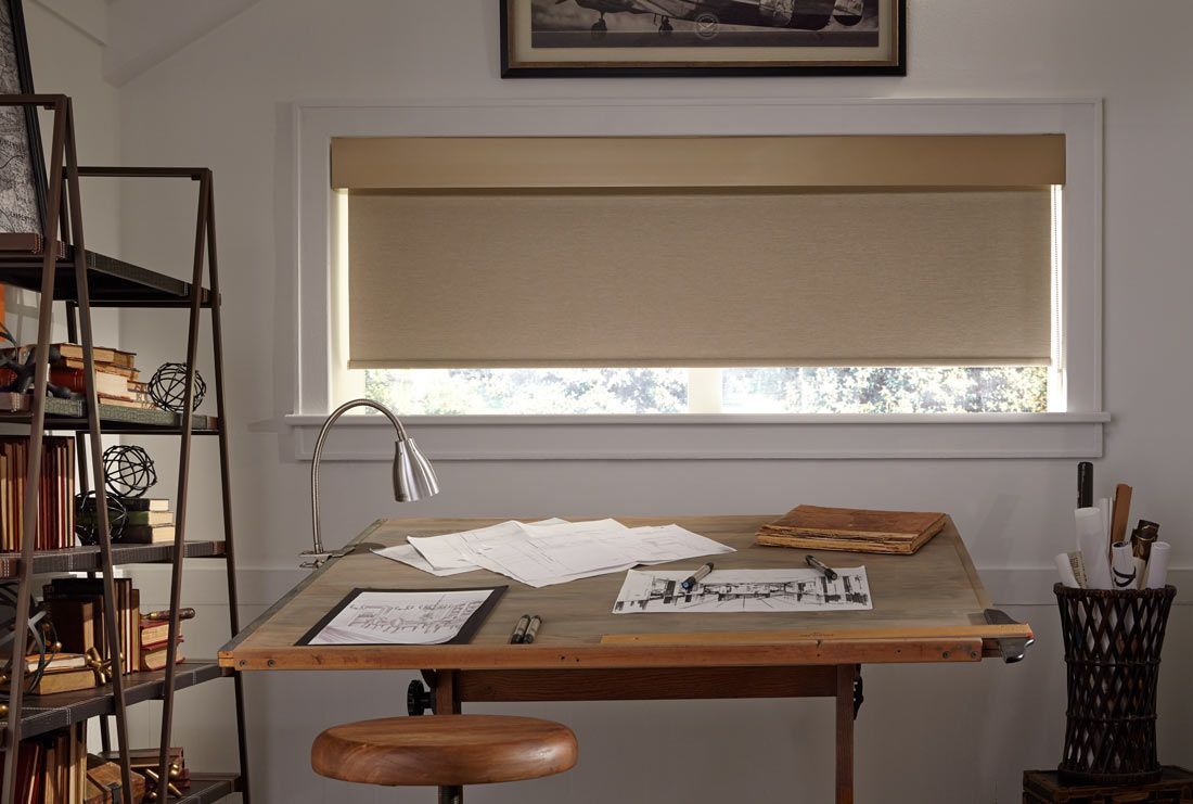 a room with a table and a window with roller shades on it All Window Decor (817) 448-3393.