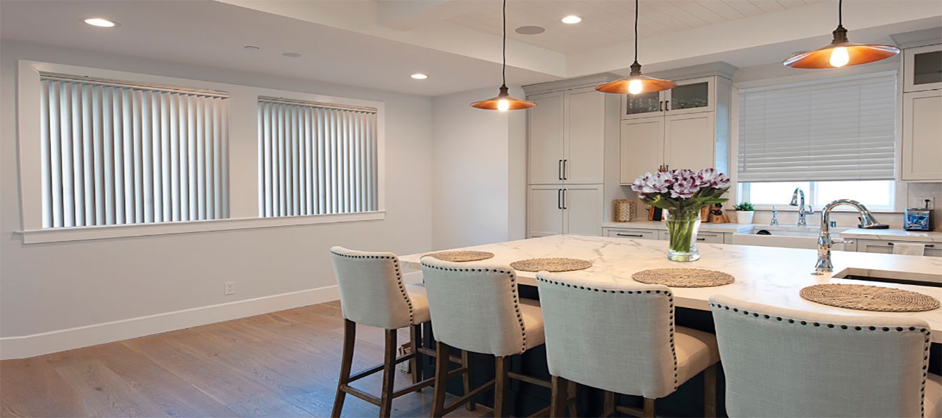 a kitchen with a large island , chairs , and a vase of flowers All Window Decor (817) 448-3393.