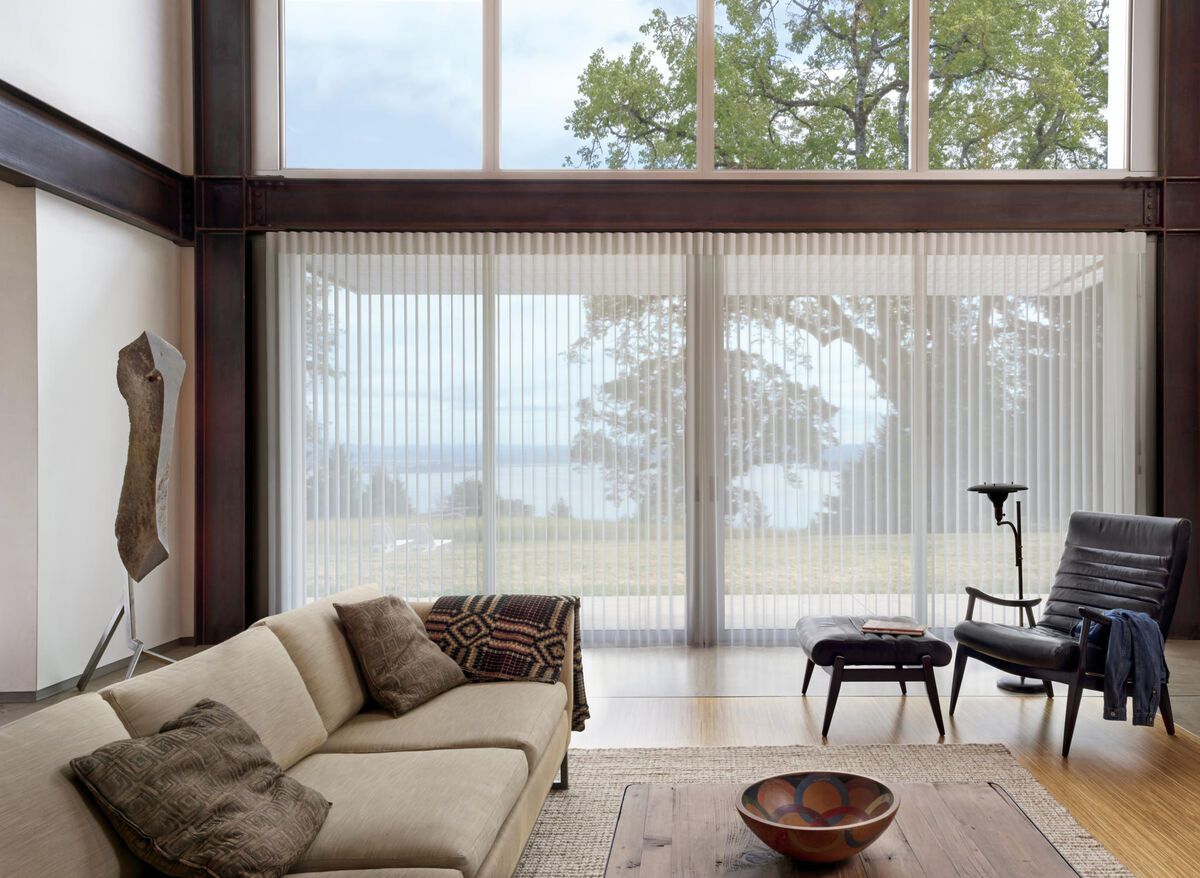 a living room with a couch , chair , coffee table and large windows with vertical blinds All Window Decor (817) 448-3393.