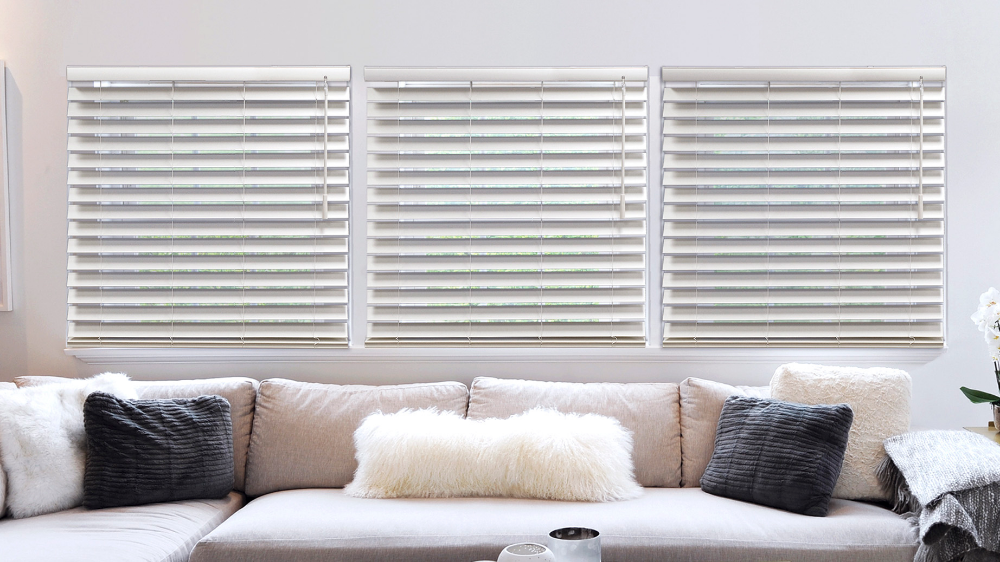 a living room with a couch , pillows , and blinds on the windows All Window Decor (817) 448-3393.