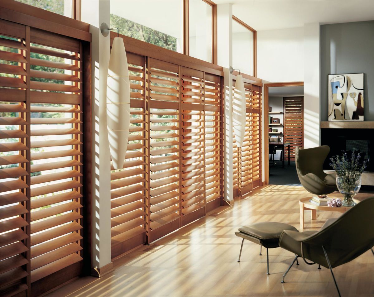 a living room with wooden shutters on the windows All Window Decor (817) 448-3393