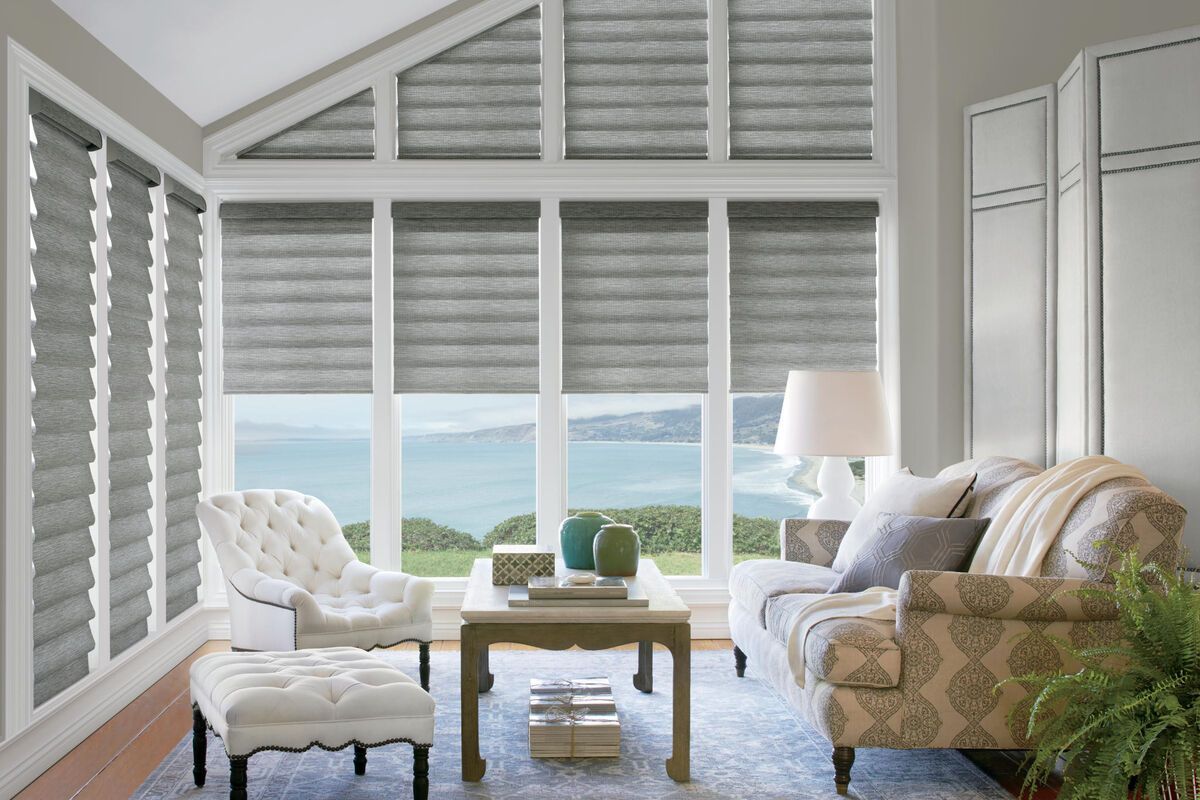 a living room with a couch , chair , coffee table and ottoman with shades All Window Decor (817) 448-3393.