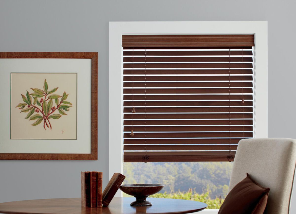 a living room with wooden blinds and a table and chair All Window Decor (817) 448-3393