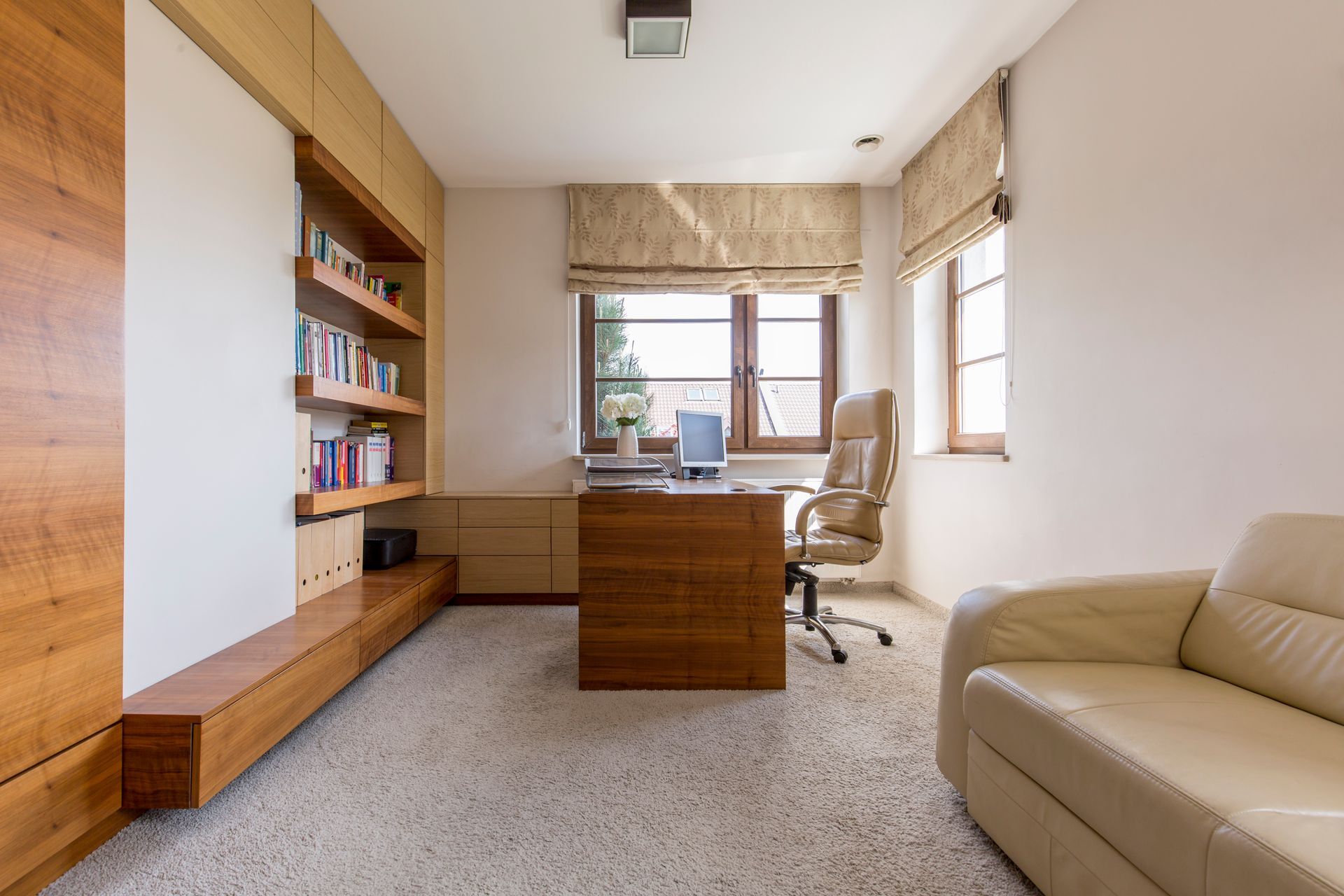 a living room with a couch , desk , chair and window with roman shades All Window Decor (817) 448-3393.