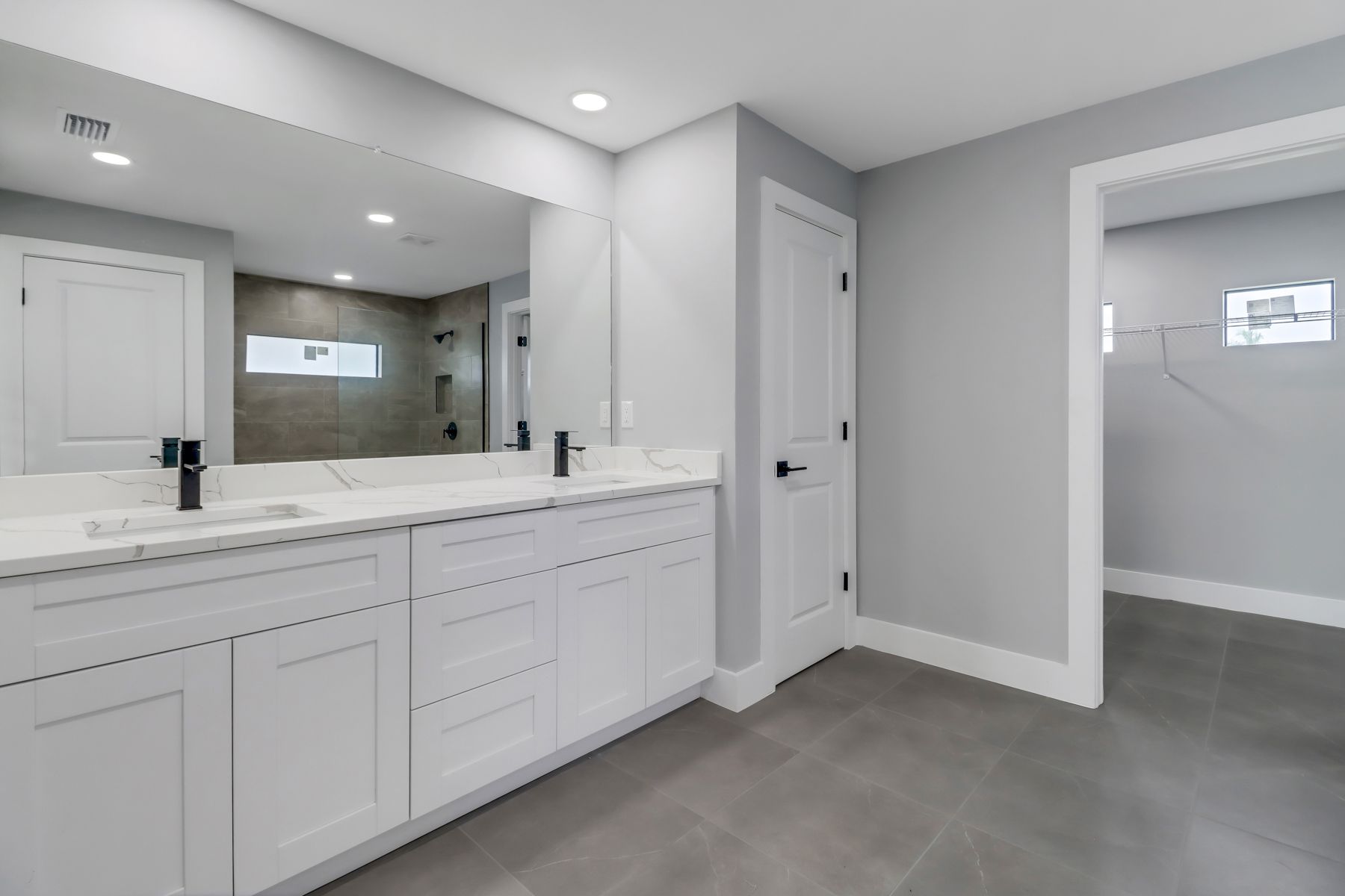 an empty room with a ceiling fan and gray carpet