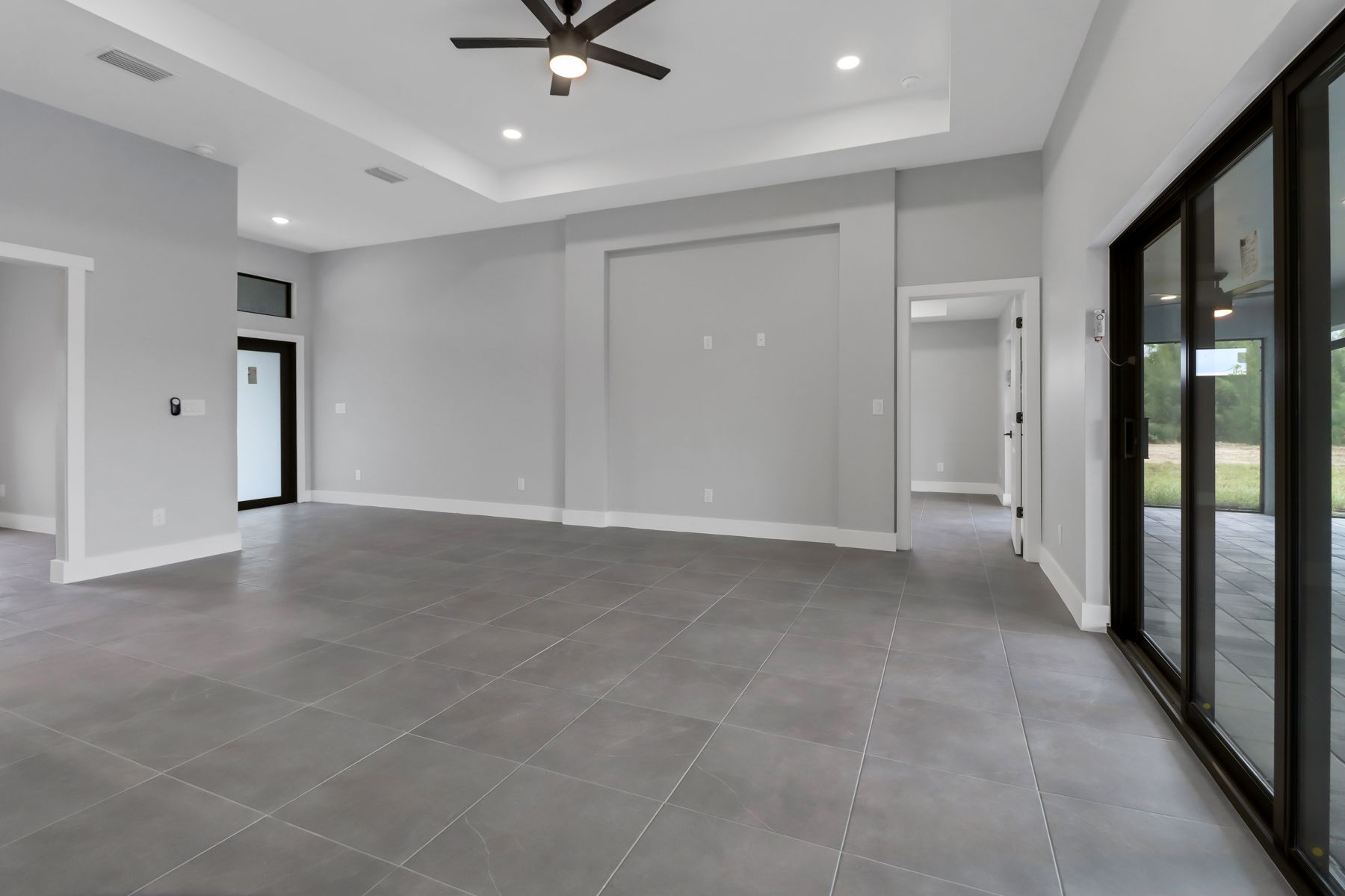 an empty living room with hardwood floors and a ceiling fan .