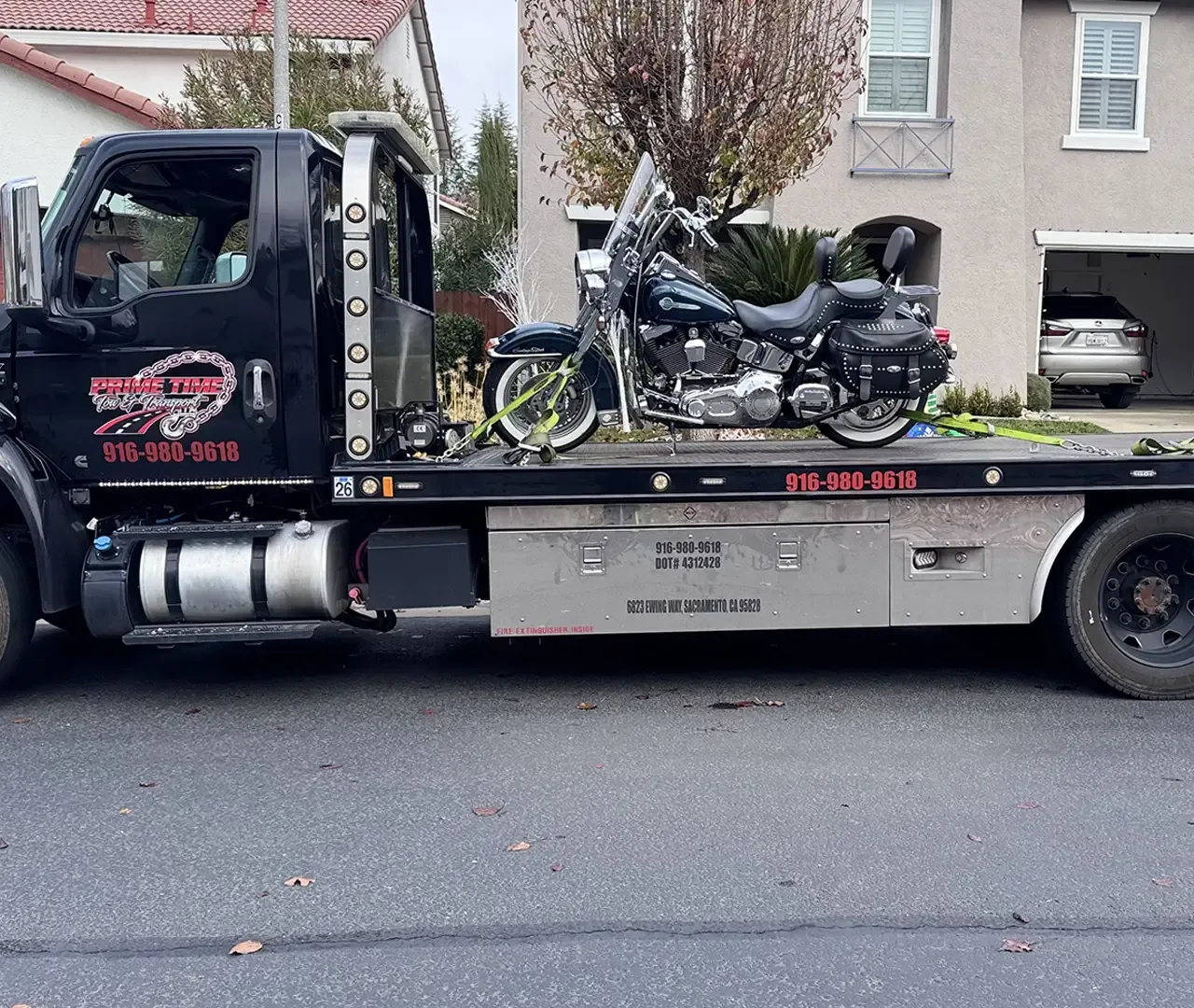 A motorcycle is on the back of a tow truck