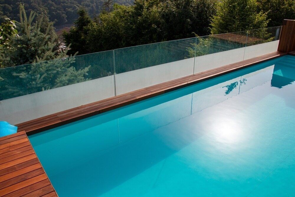 A  Pool With A Glass Fence Around It — Diverse Poolcare–Pool Fence Inspections & Compliance Certificates In Wagga Wagga, NSW