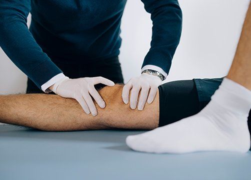 Therapist Adjusting Patient Knee — Wichita, KS — Advanced Chiropractic Therapist Adjusting Patient Knee — Wichita, KS — Advanced Chiropractic
