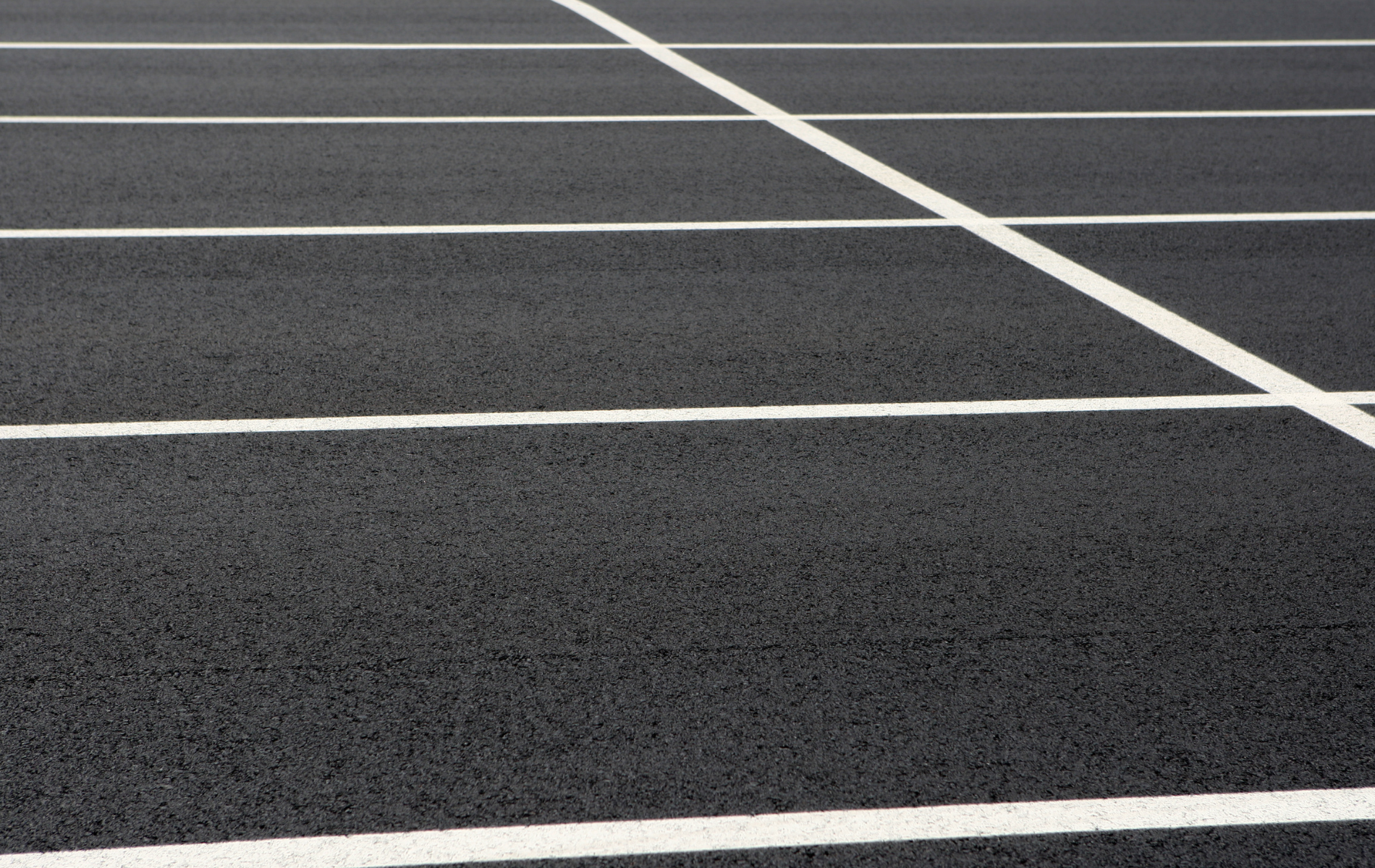 A close up of a parking lot with white lines on it.