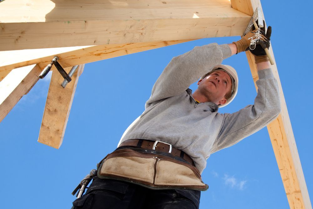 Carpenter in A Hard Hat Works on A Wooden Roof Structure — Lunny's Carpentry In Mooloolaba, QLD