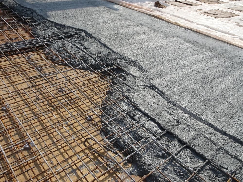 Concrete Being Poured Over Rebar Mesh on A Wooden Surface — Lunny's Carpentry In Dubbo, NSW