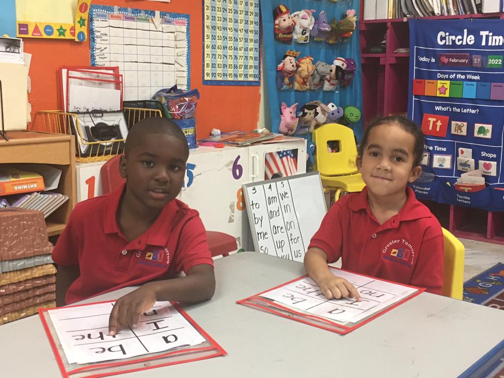 A boy and a girl are sitting at a table in a classroom.