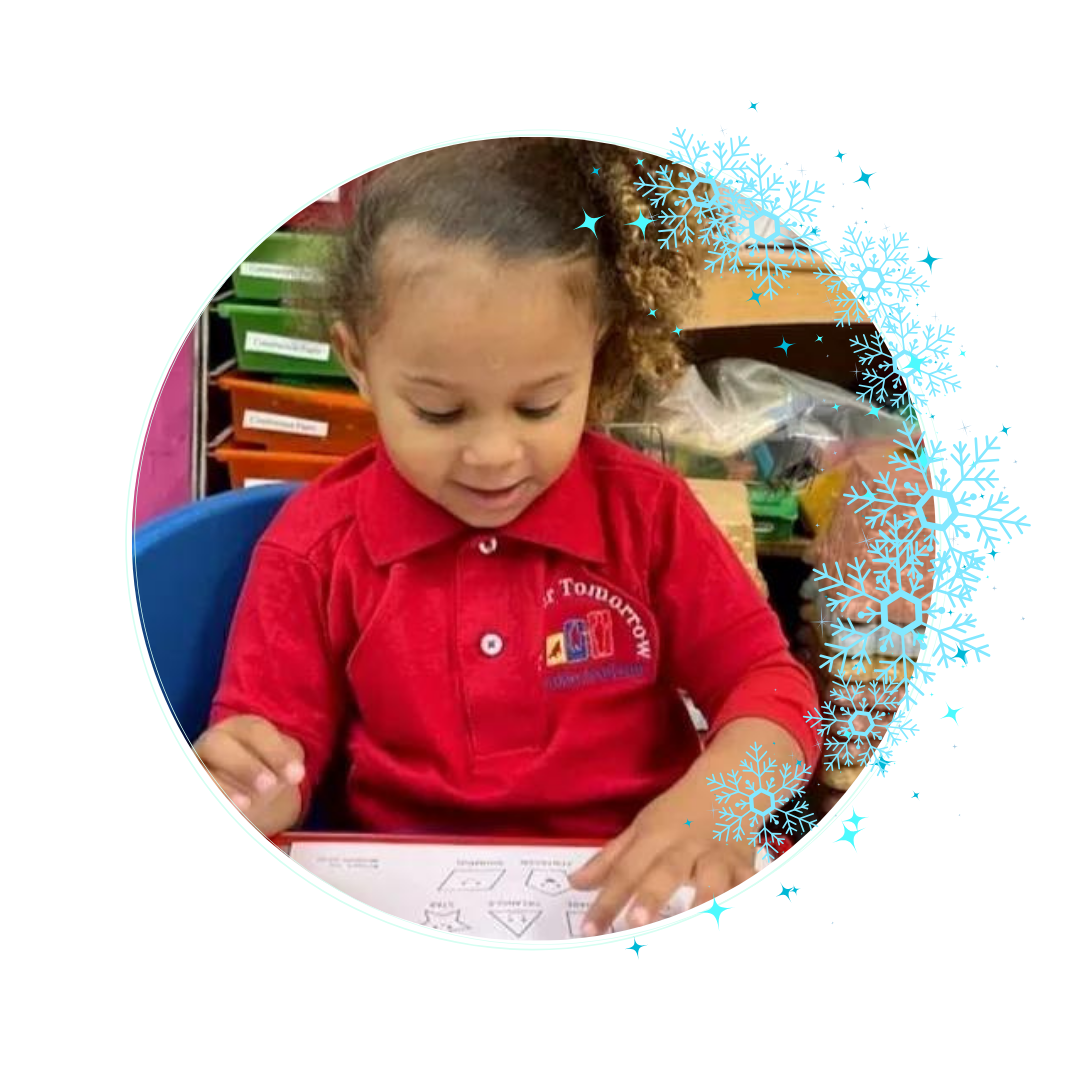 A little girl in a red shirt is sitting at a table