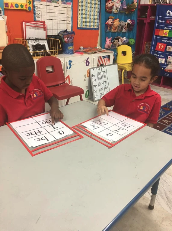 A boy and a girl are sitting at a table in a classroom