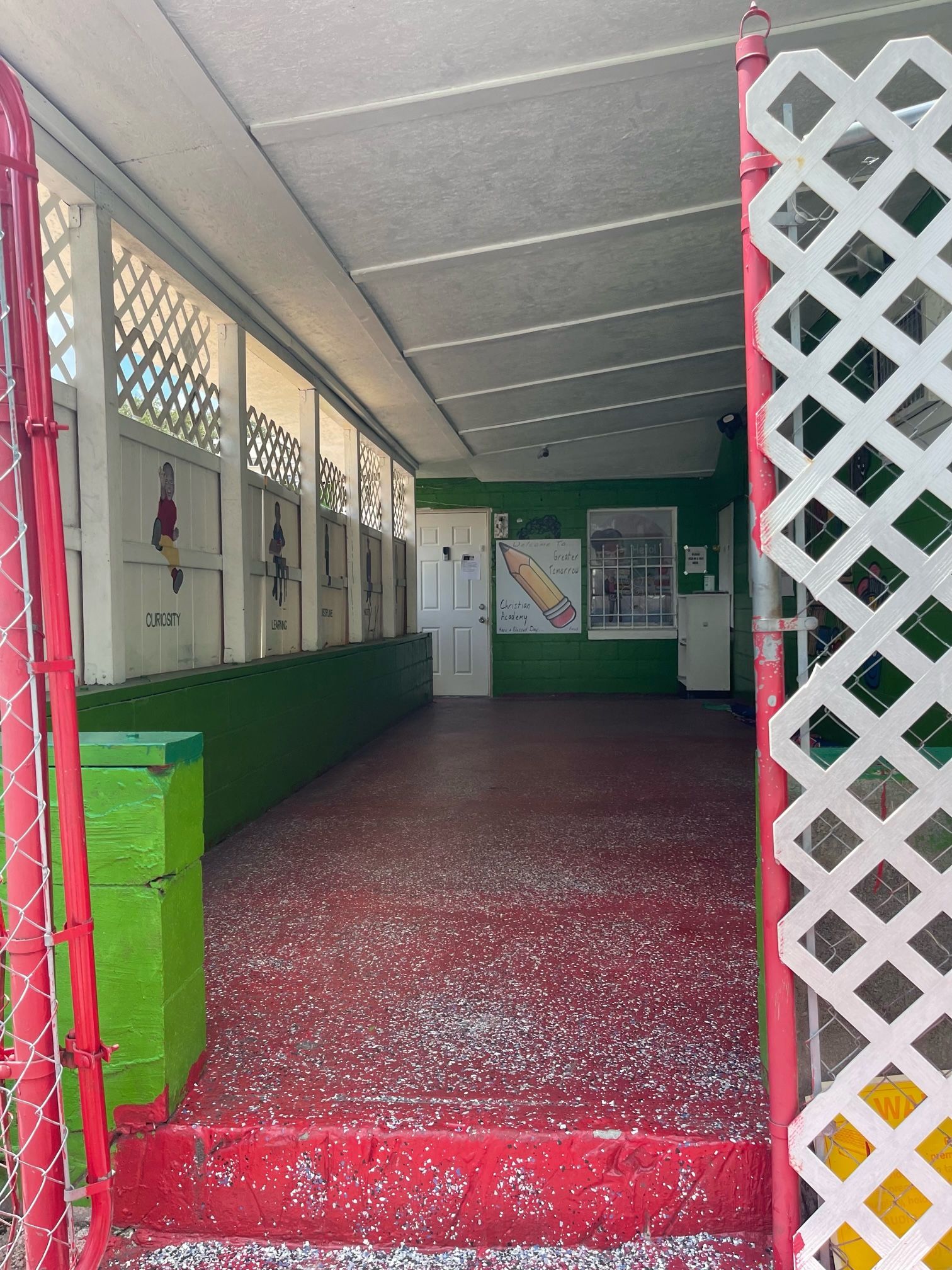 An empty hallway with a red floor and a white lattice fence.