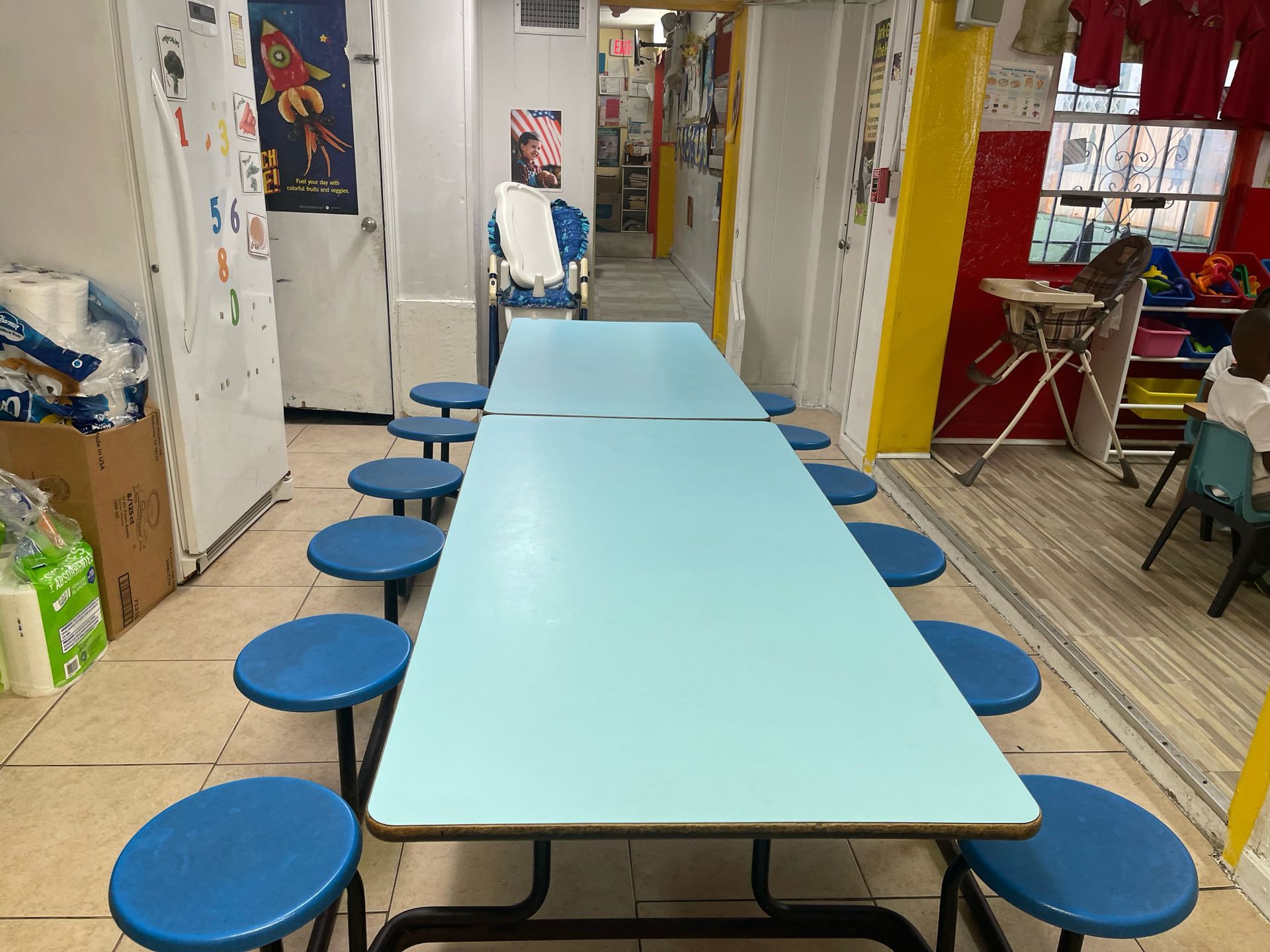 A long blue table with blue stools in a room