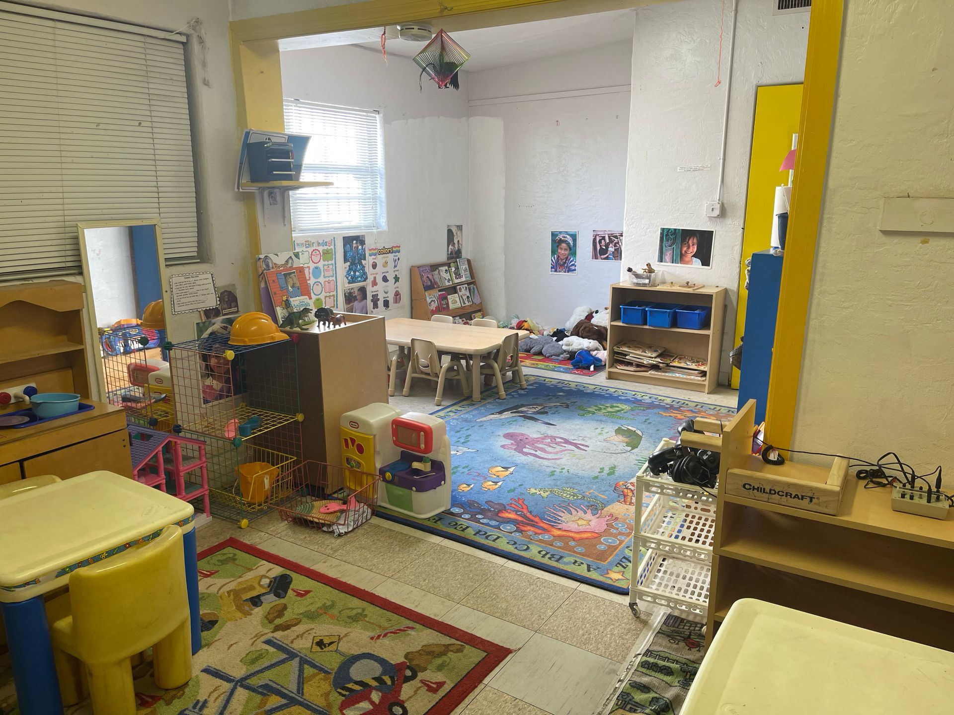 A room filled with lots of toys and tables and chairs.