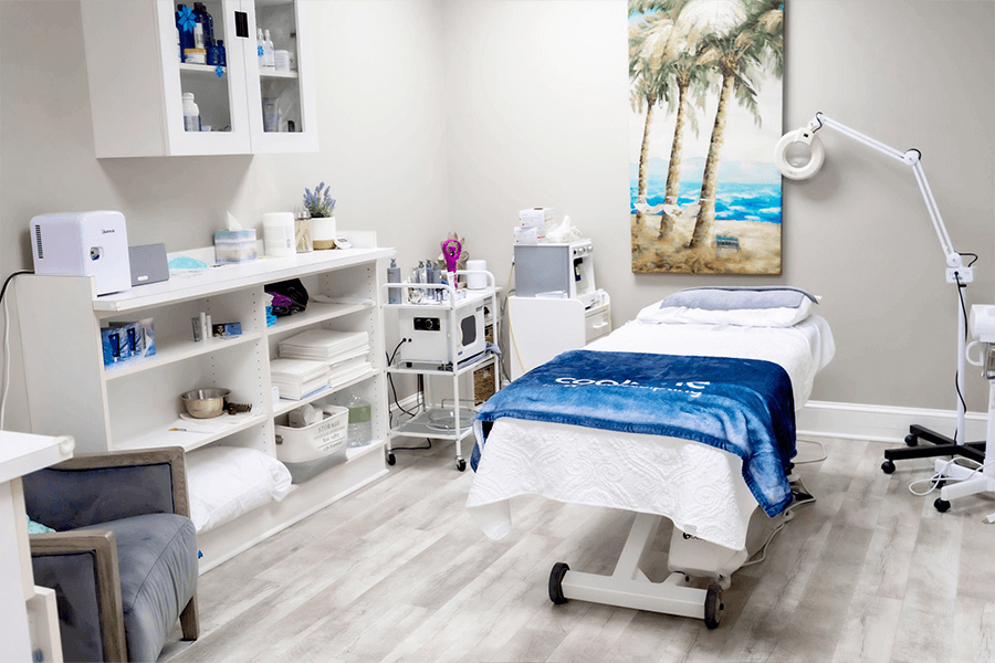 A room with a massage table and a painting on the wall.