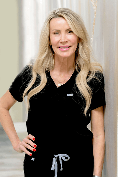 a woman is posing for a picture wearing a black t shirt and a silver necklace