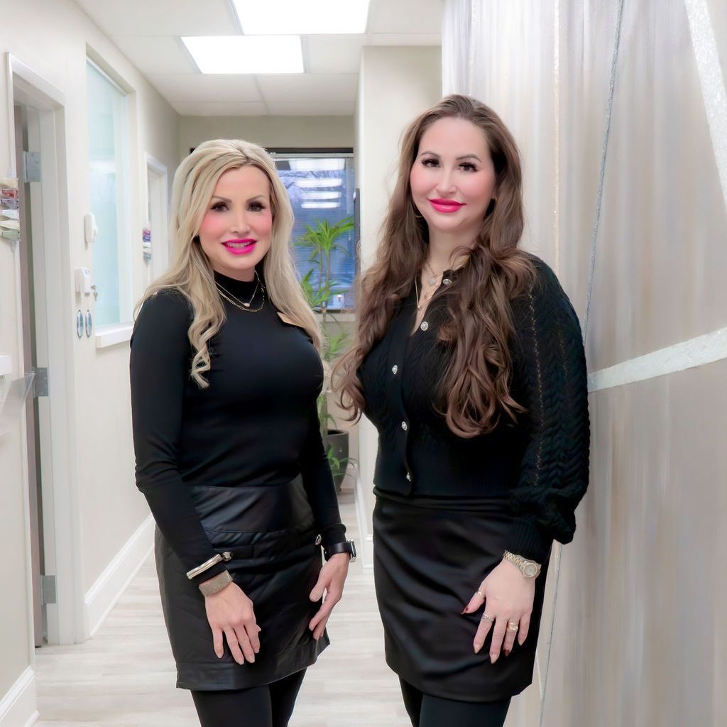 Two women standing next to each other in a hallway