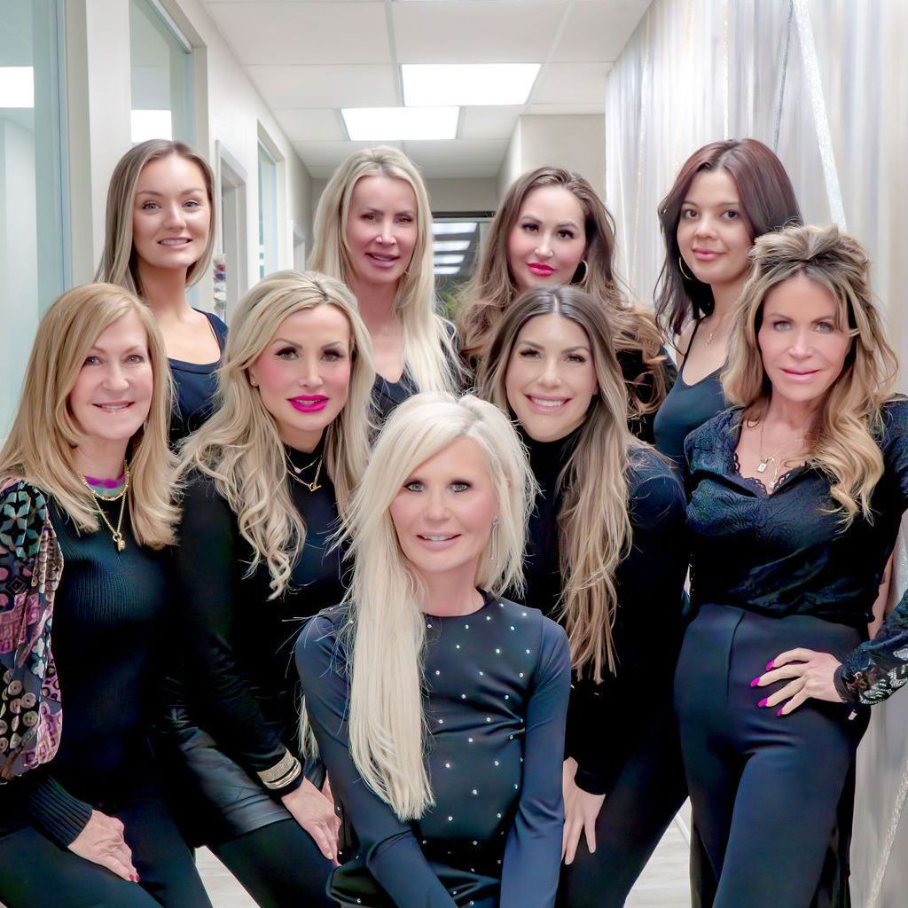 A group of women are posing for a picture in a hallway.
