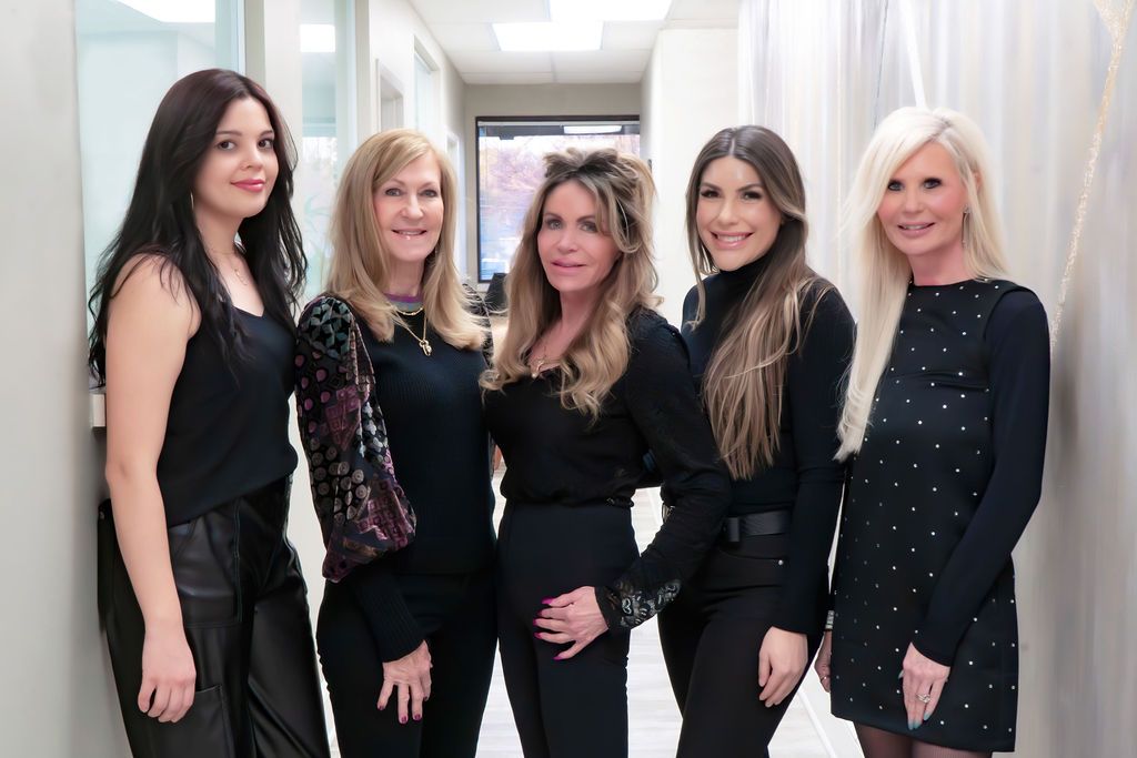 A group of women are posing for a picture in a hallway.
