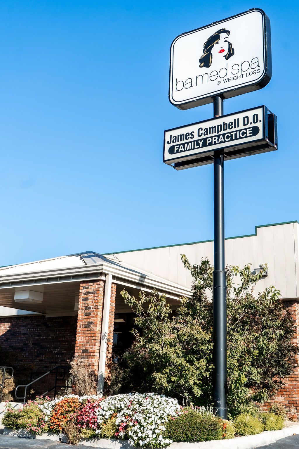 A large sign on a pole in front of a building.