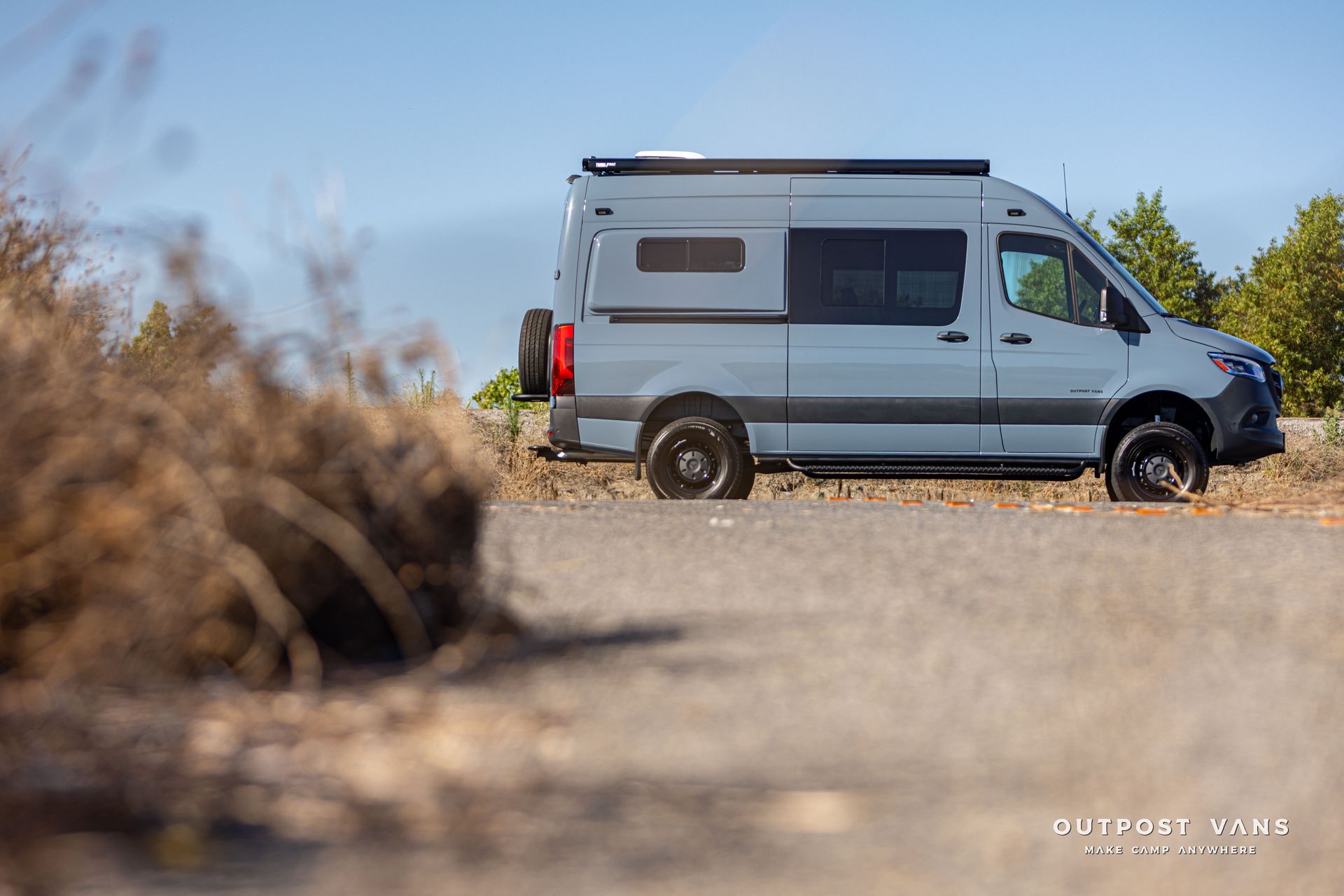 A gray van is parked on the side of a road.