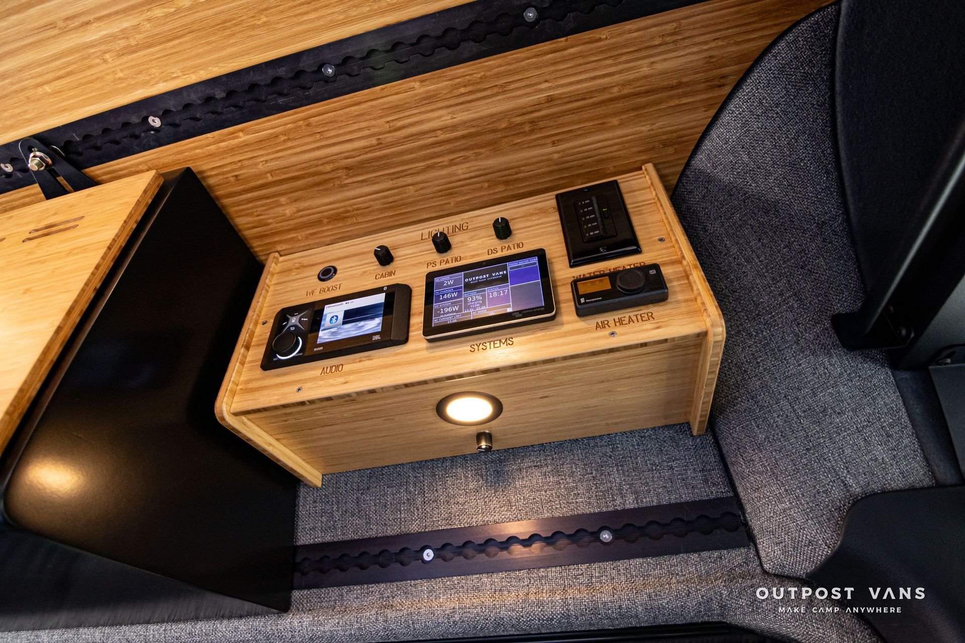 A wooden table with a tablet on top of it in a van.