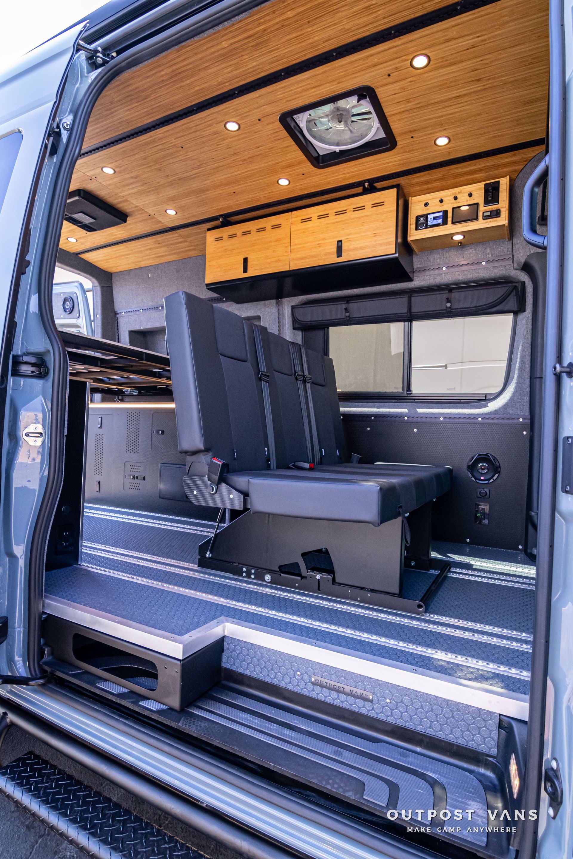 The inside of a van with the door open and the seats folded down.