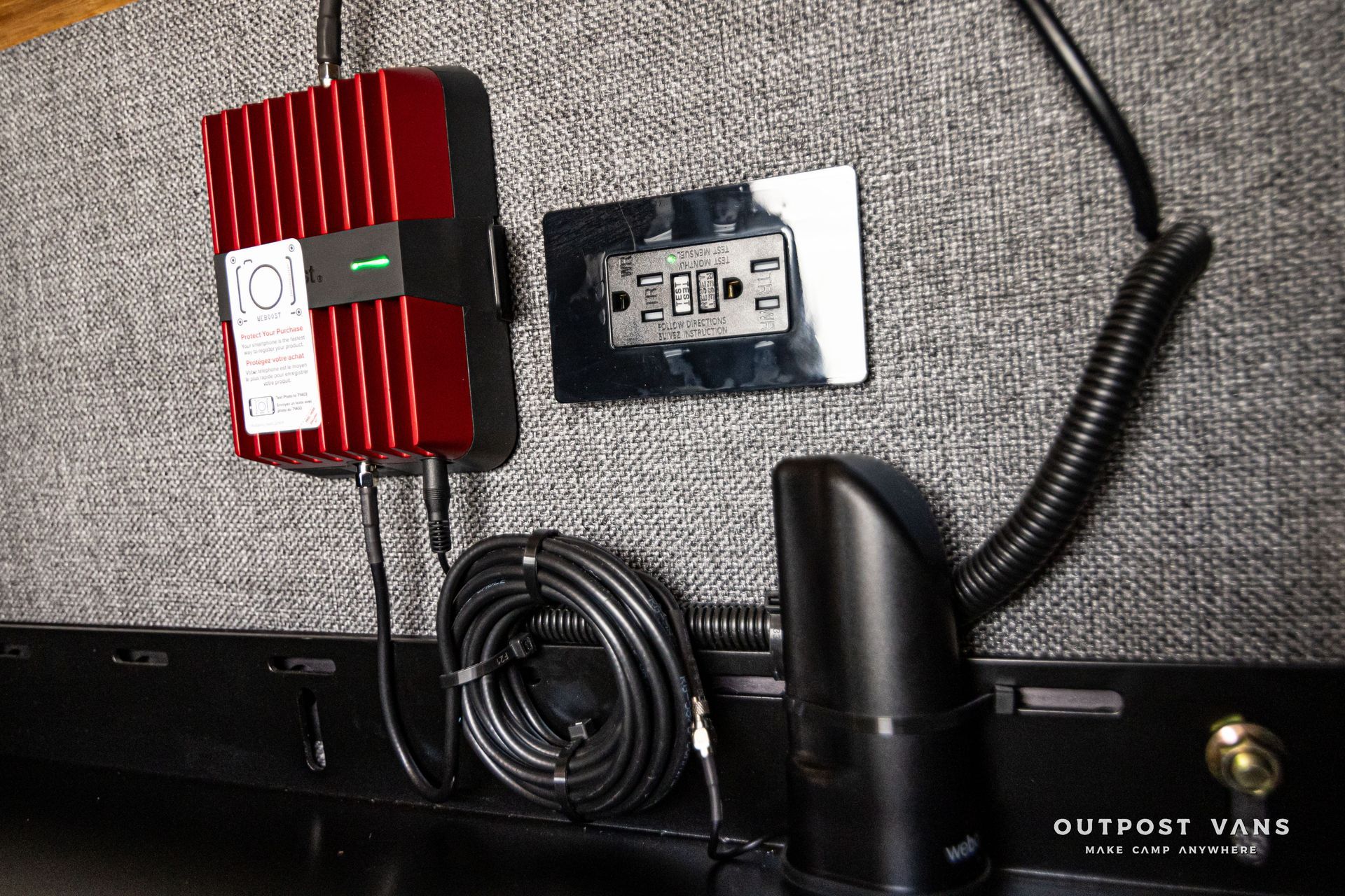 A cell phone antenna is plugged into a wall socket.