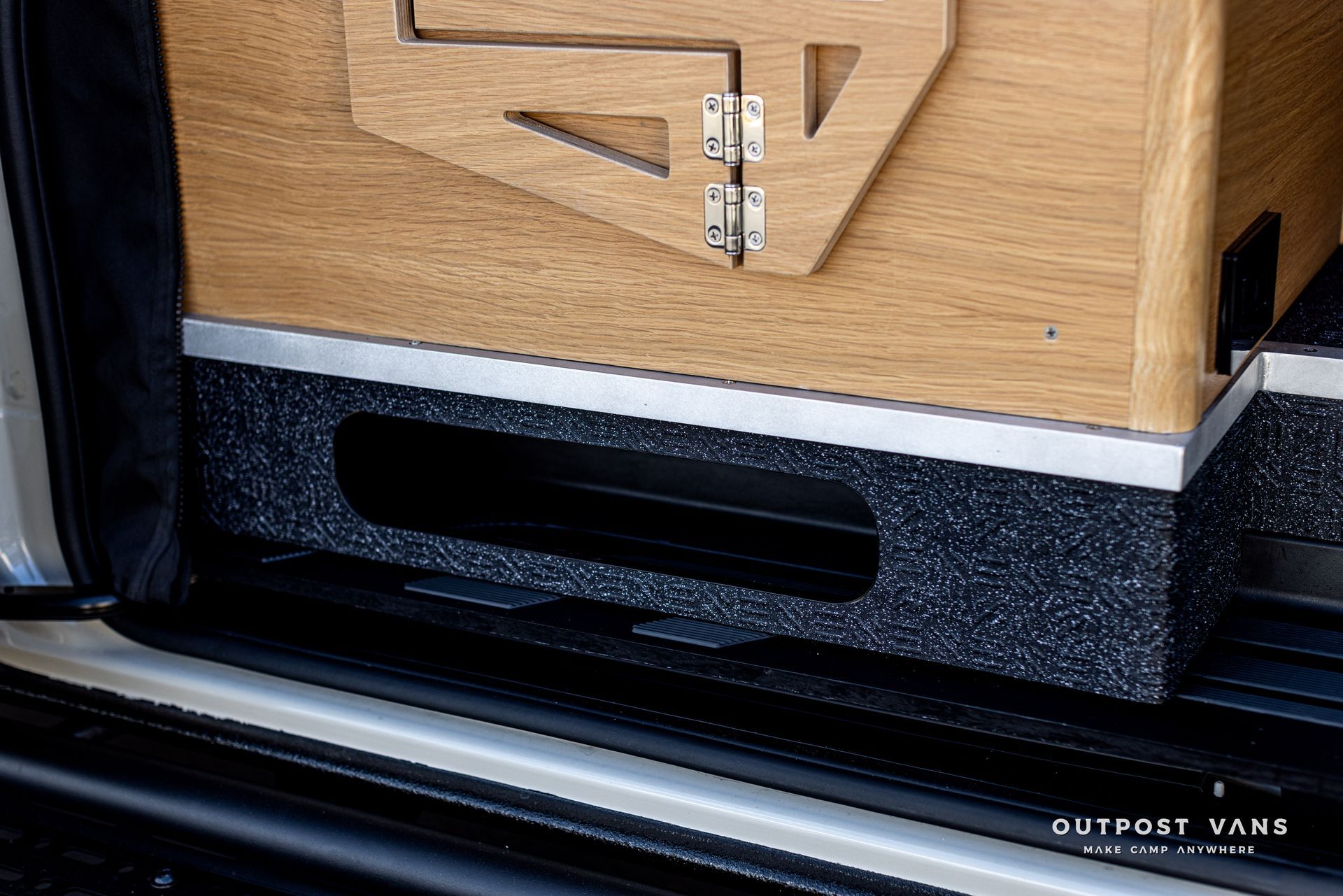 A wooden box is sitting in the back of a van.