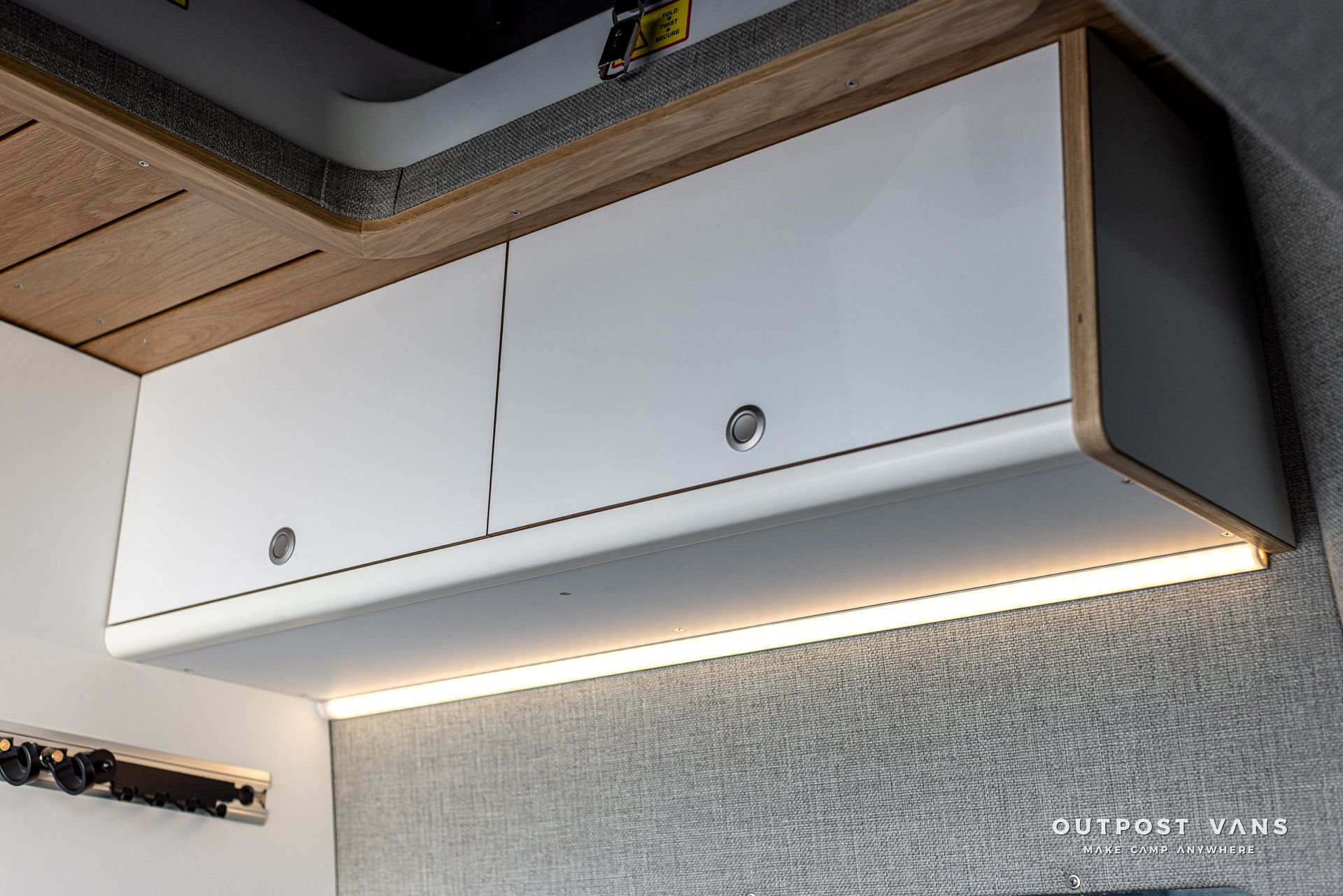 A white cabinet with a light underneath it in a kitchen.