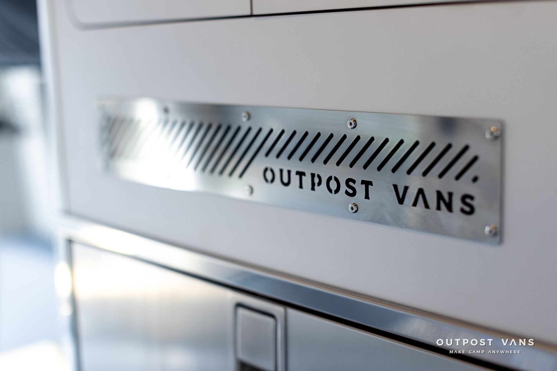 A sign on the side of a van that says outpost vans